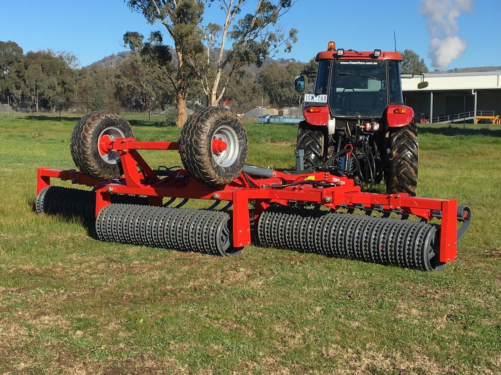 A red and white tractor with a trailer attached to it on a white background.