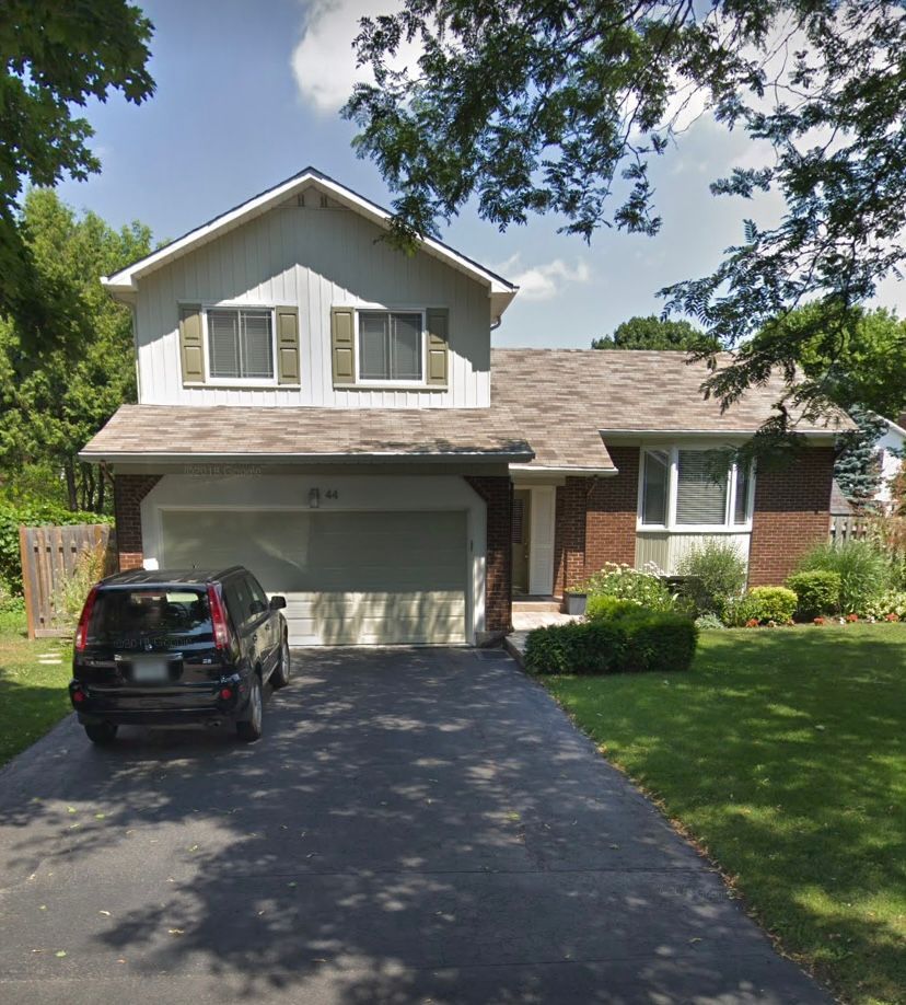 A car is parked in front of a brick house