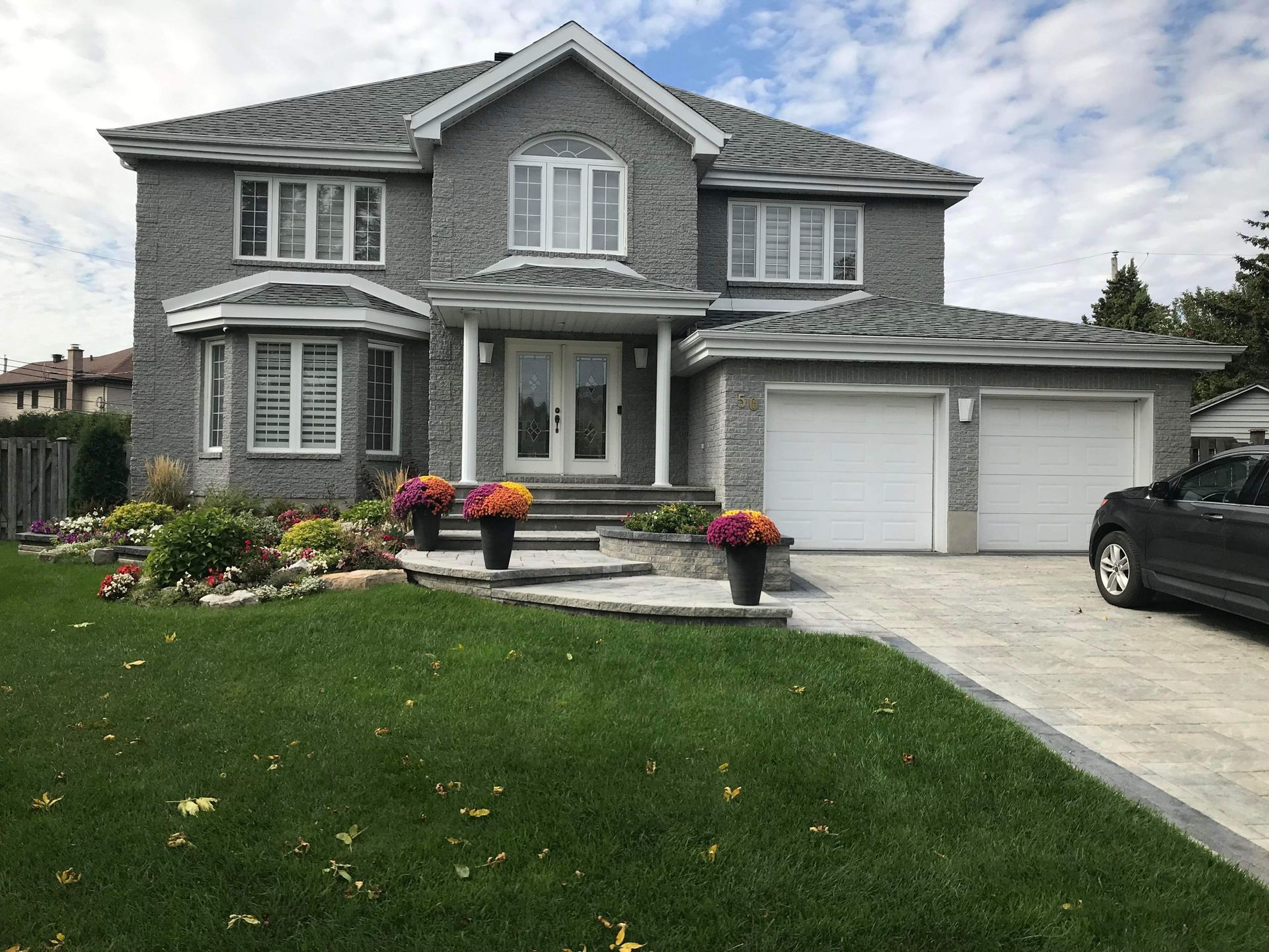 A large house with a car parked in front of it.