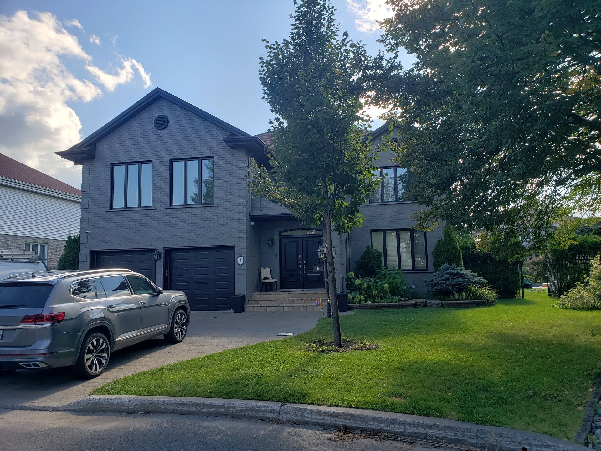 A car is parked in front of a large house.