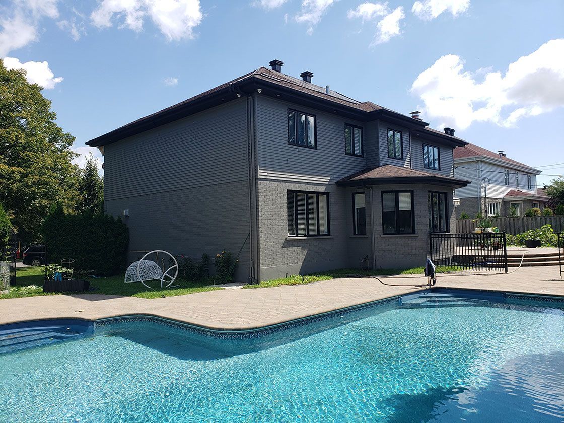 A large house with a large swimming pool in front of it.