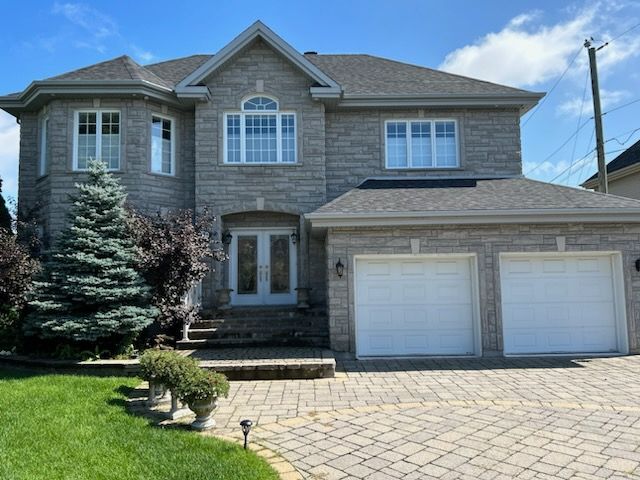 A large brick house with two white garage doors