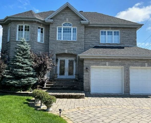 A large brick house with two white garage doors