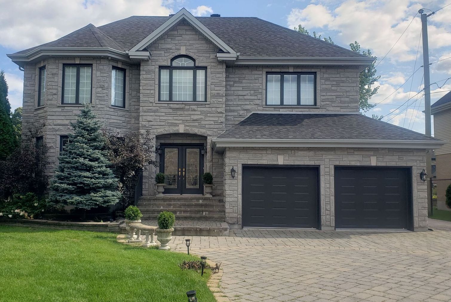 A large brick house with two garages and a driveway.