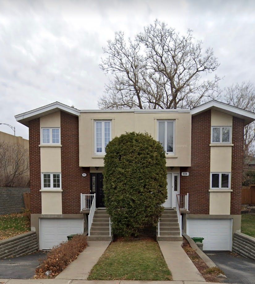 A house with two garages and stairs leading up to it