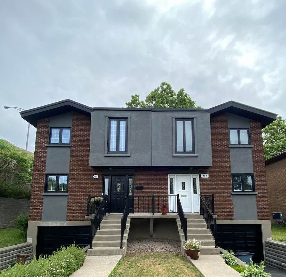 A brick house with stairs leading up to the front door