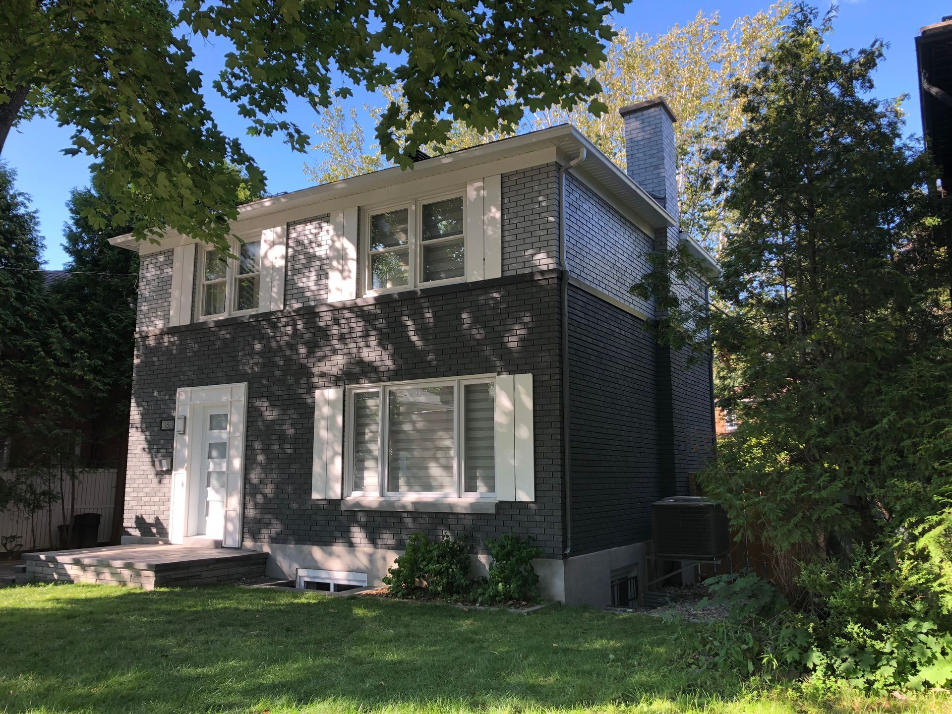 A large house with a lot of windows is surrounded by trees