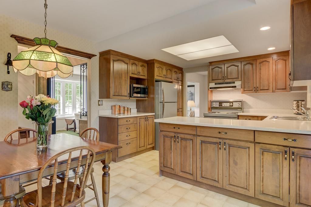 A kitchen with wooden cabinets and a table and chairs