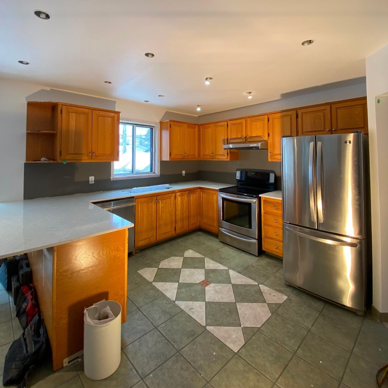 A kitchen with stainless steel appliances and wooden cabinets