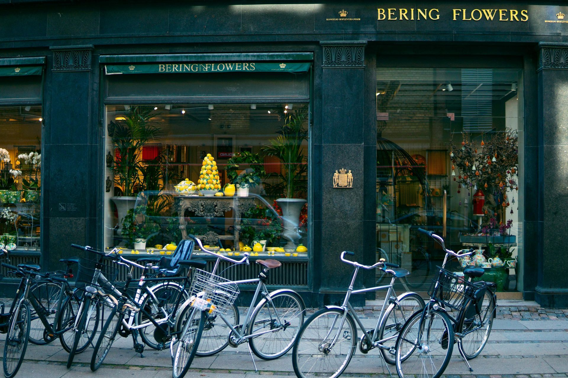 Flower shop storefront with bicycles parked outside on a rainy street