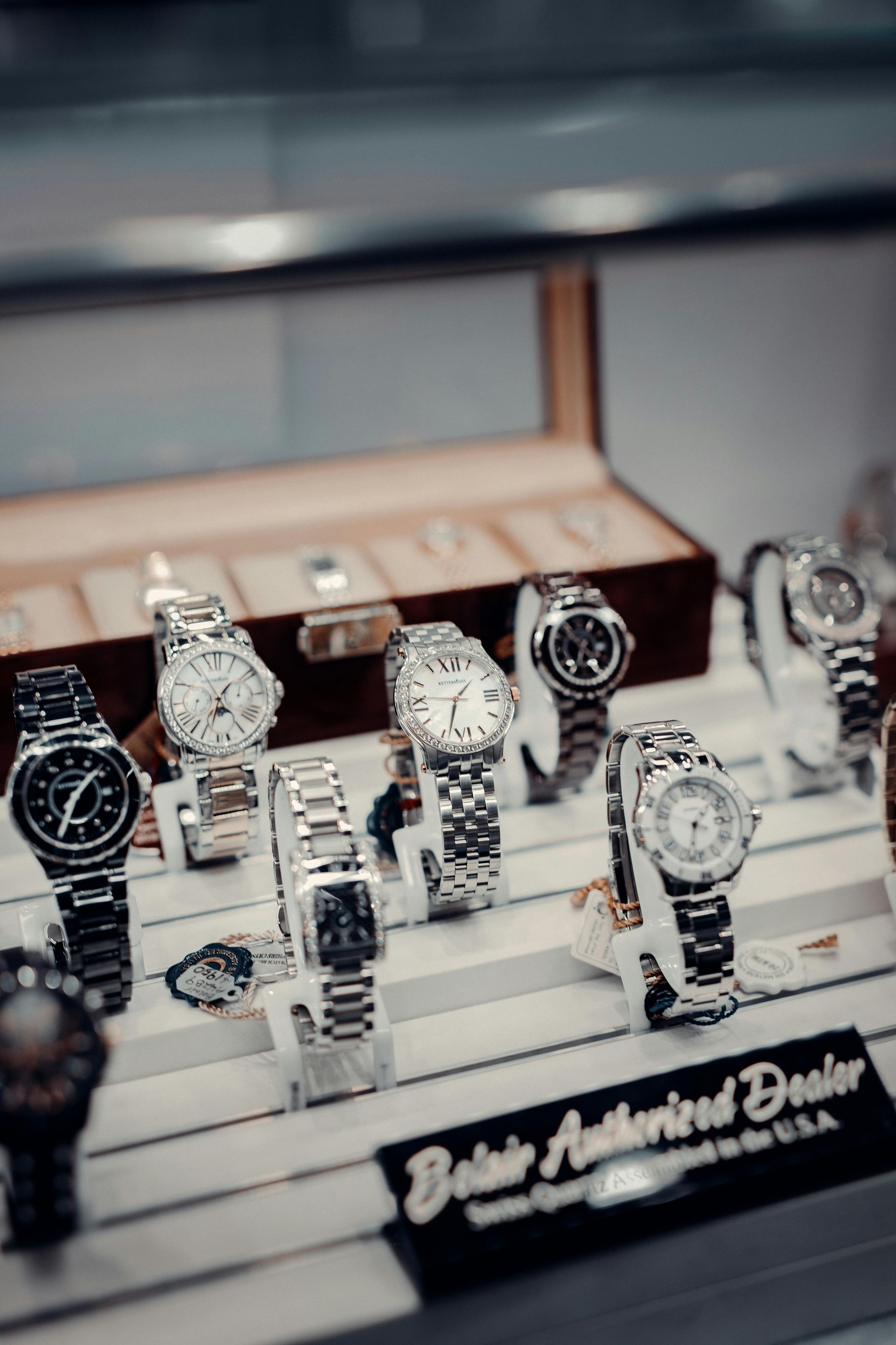Luxury wristwatches displayed in a jewelry case on clear stands