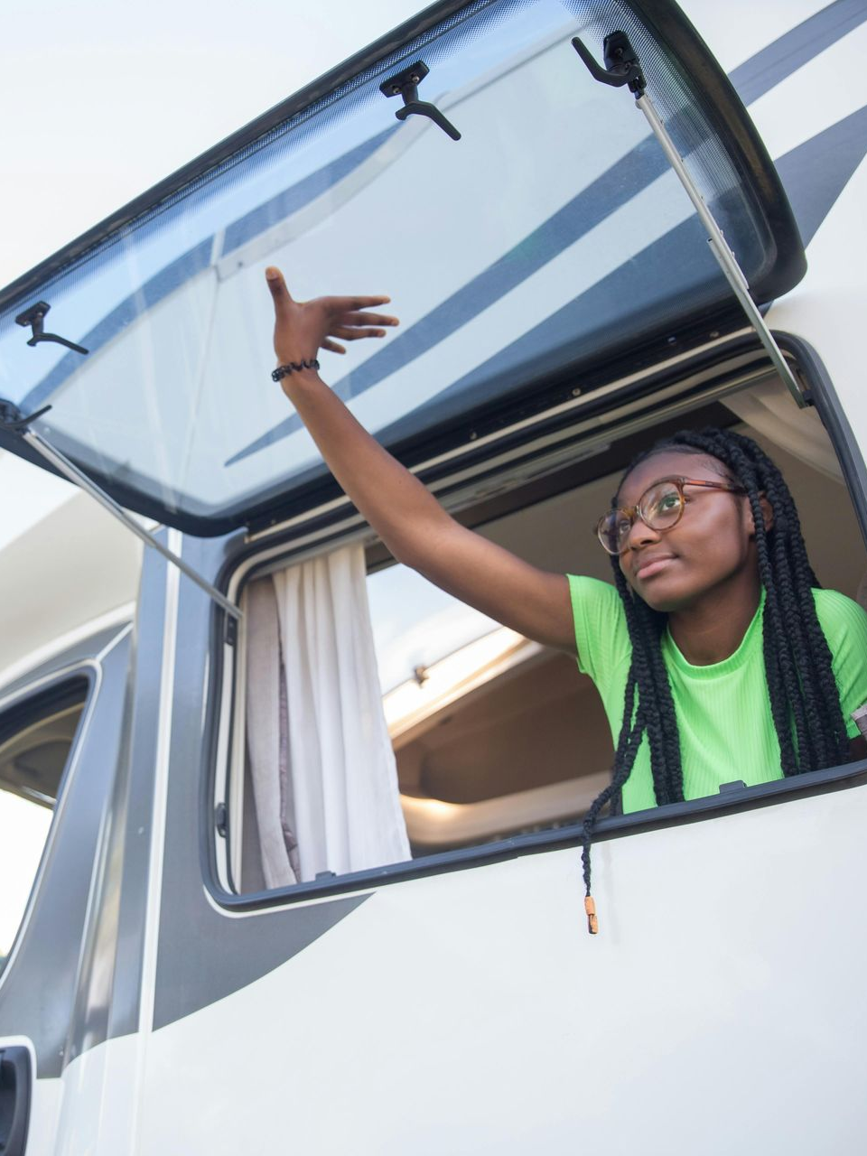 Person waving from a car window with the hatch open