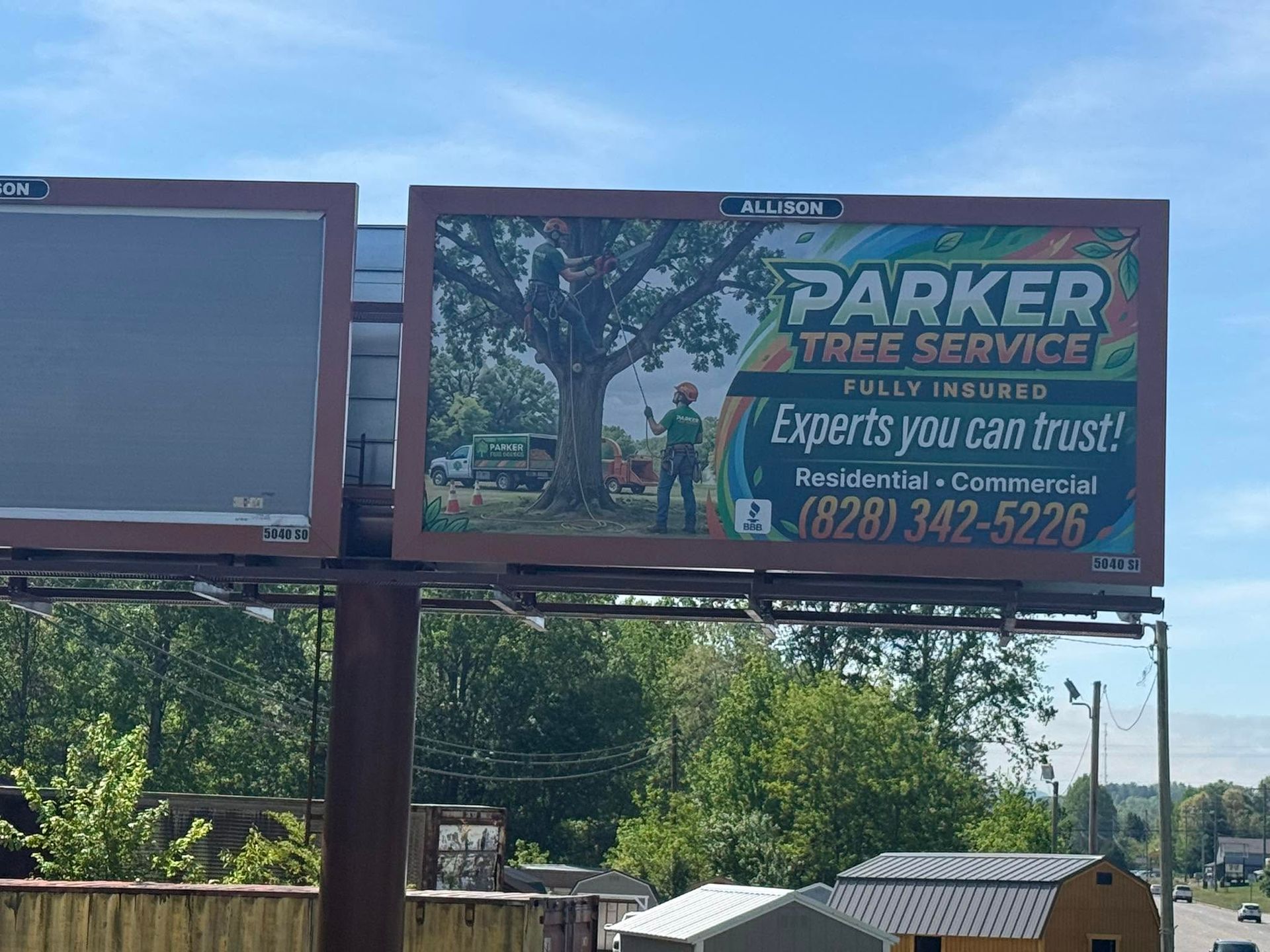 Parker Tree Service billboard with blue sky and trees in the background