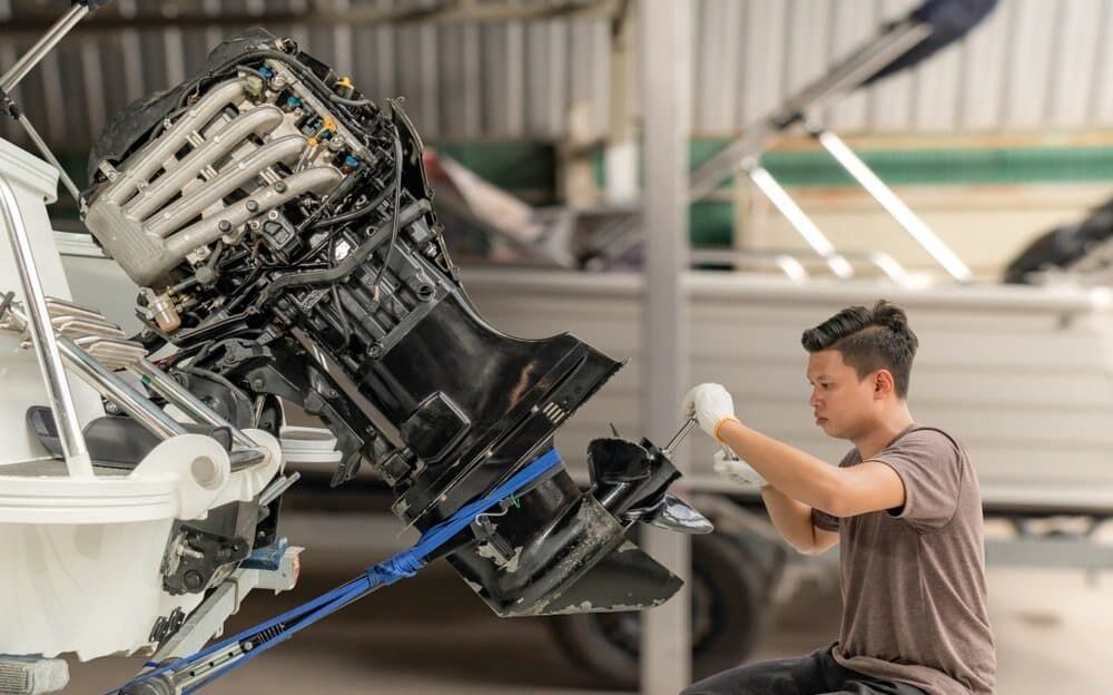 A Man is Working on the Engine of a Boat in a Garage — Clarence Valley Auto Electrical in South Grafton, NSW