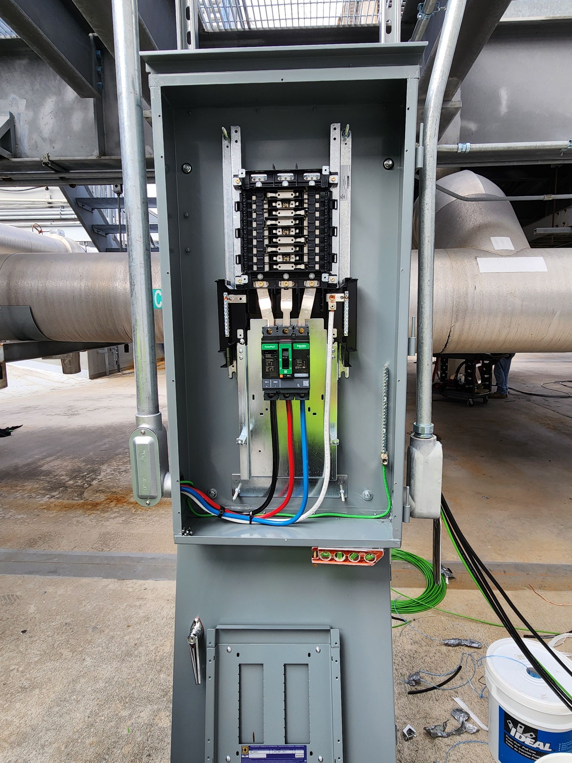 Open electrical panel with wiring and breakers in an industrial setting