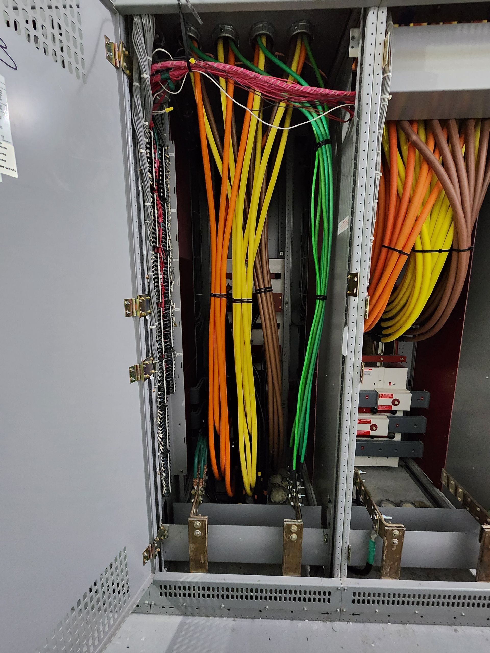 Open electrical panel with multicolored cables and wiring
