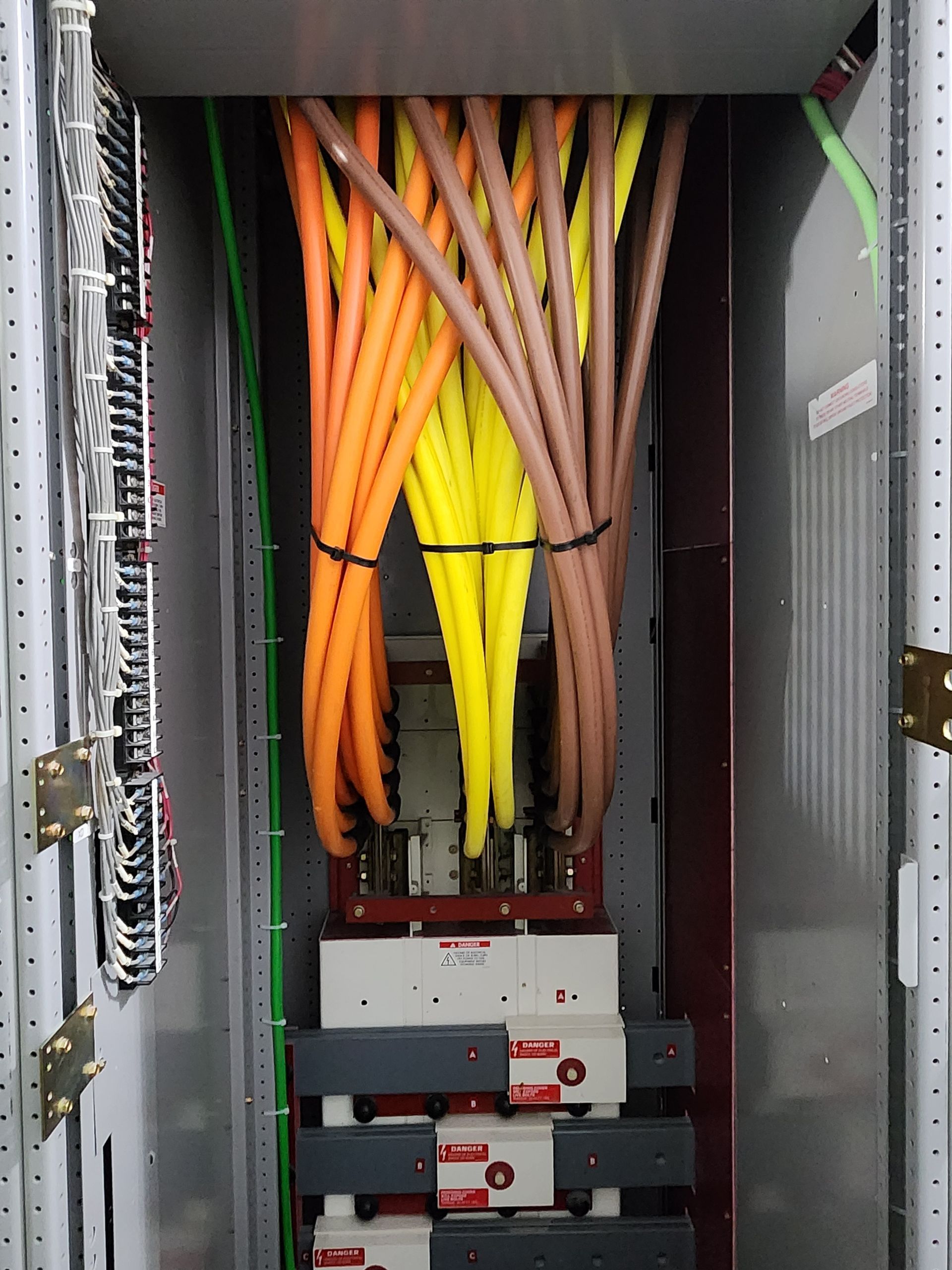 Open server rack with orange and yellow cables and electronic modules inside.