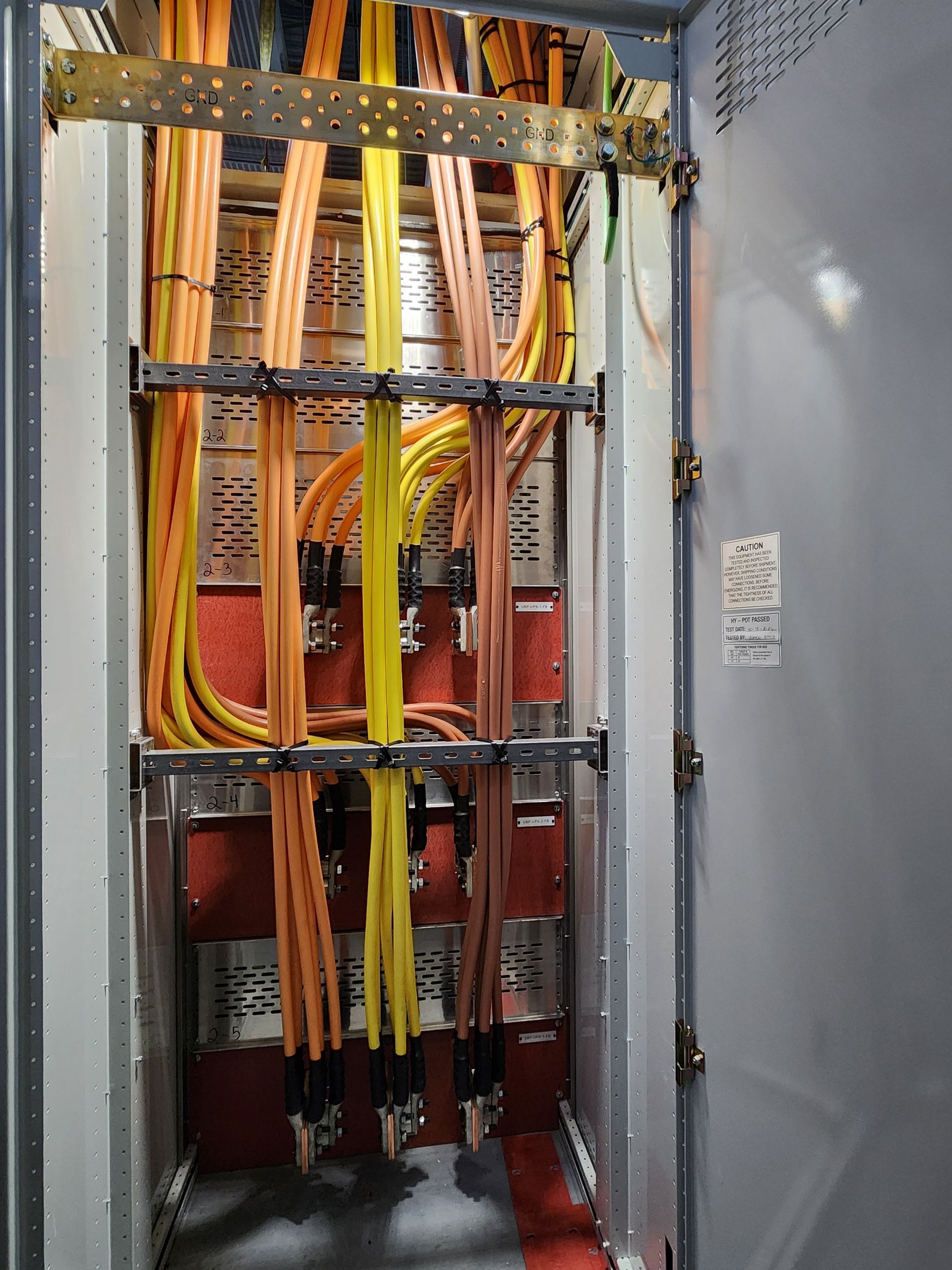 Open electrical panel with colored wires and cables inside a metal cabinet