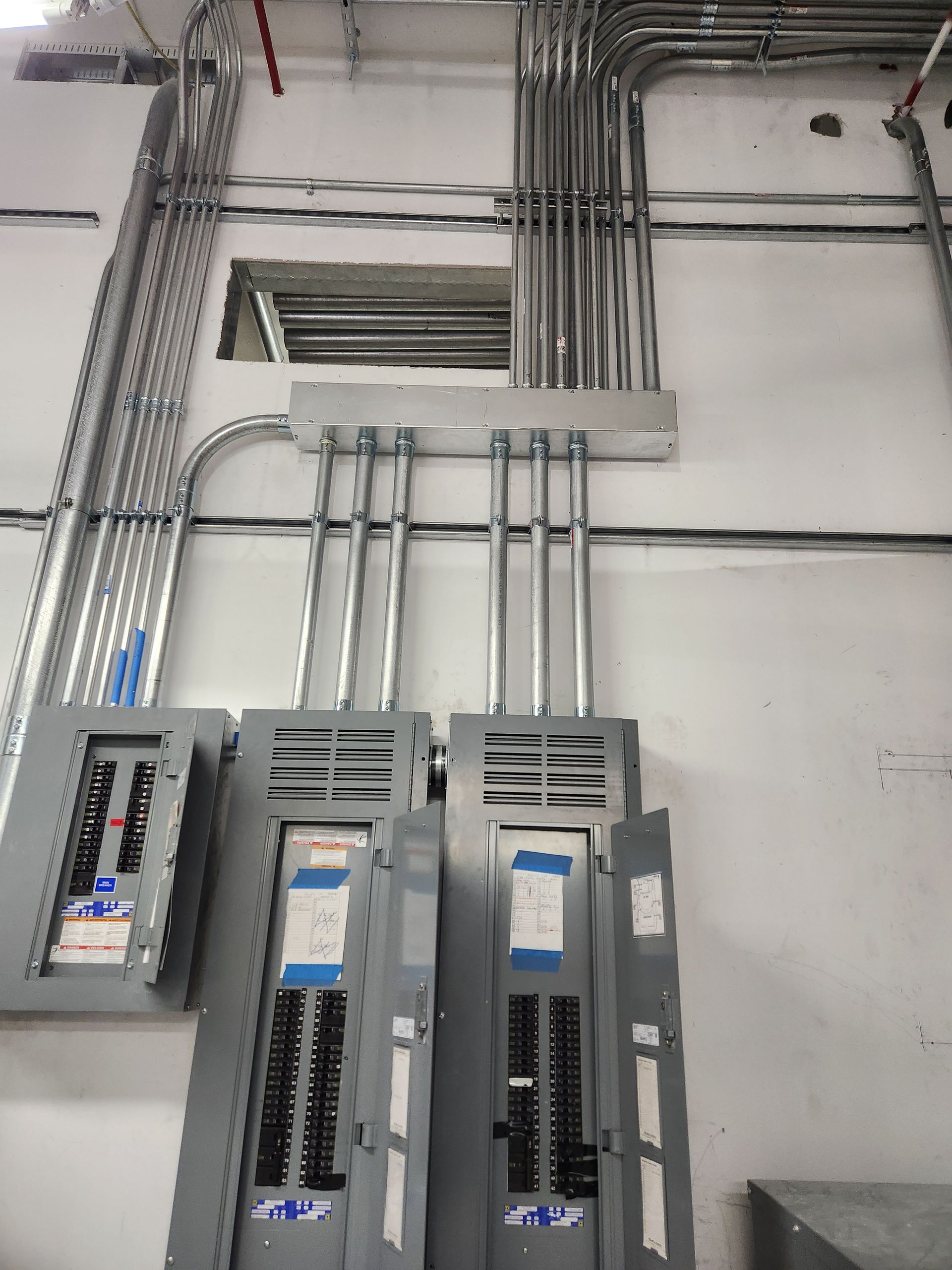 Electrical panels and conduit on a wall in a utility room