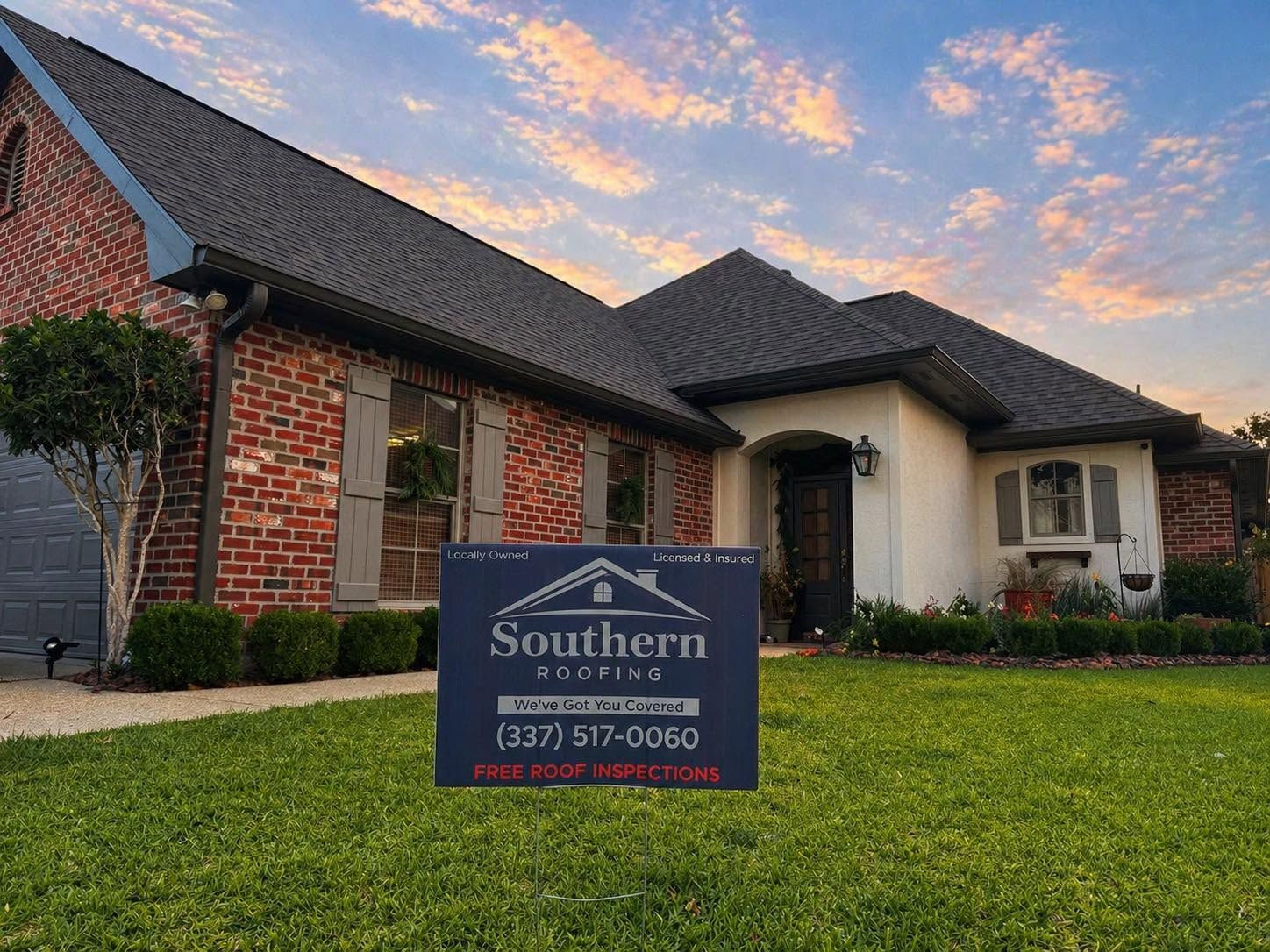 Brick suburban house at sunset with a Southern Homes real estate sign in the front yard
