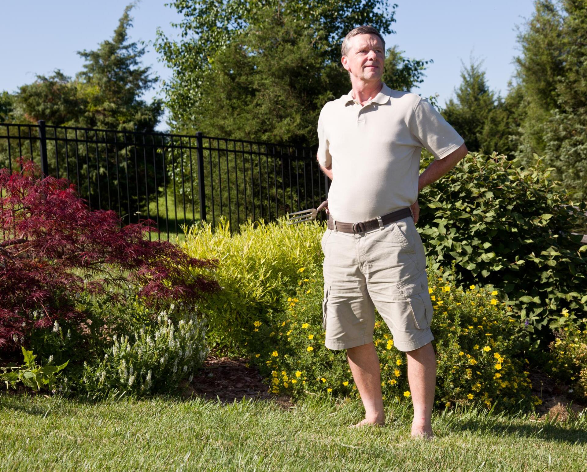 Another satisfied Yorba Landscaping customer stands in his new garden barefoot enjoying his new landscape construction in his Yorba Linda home