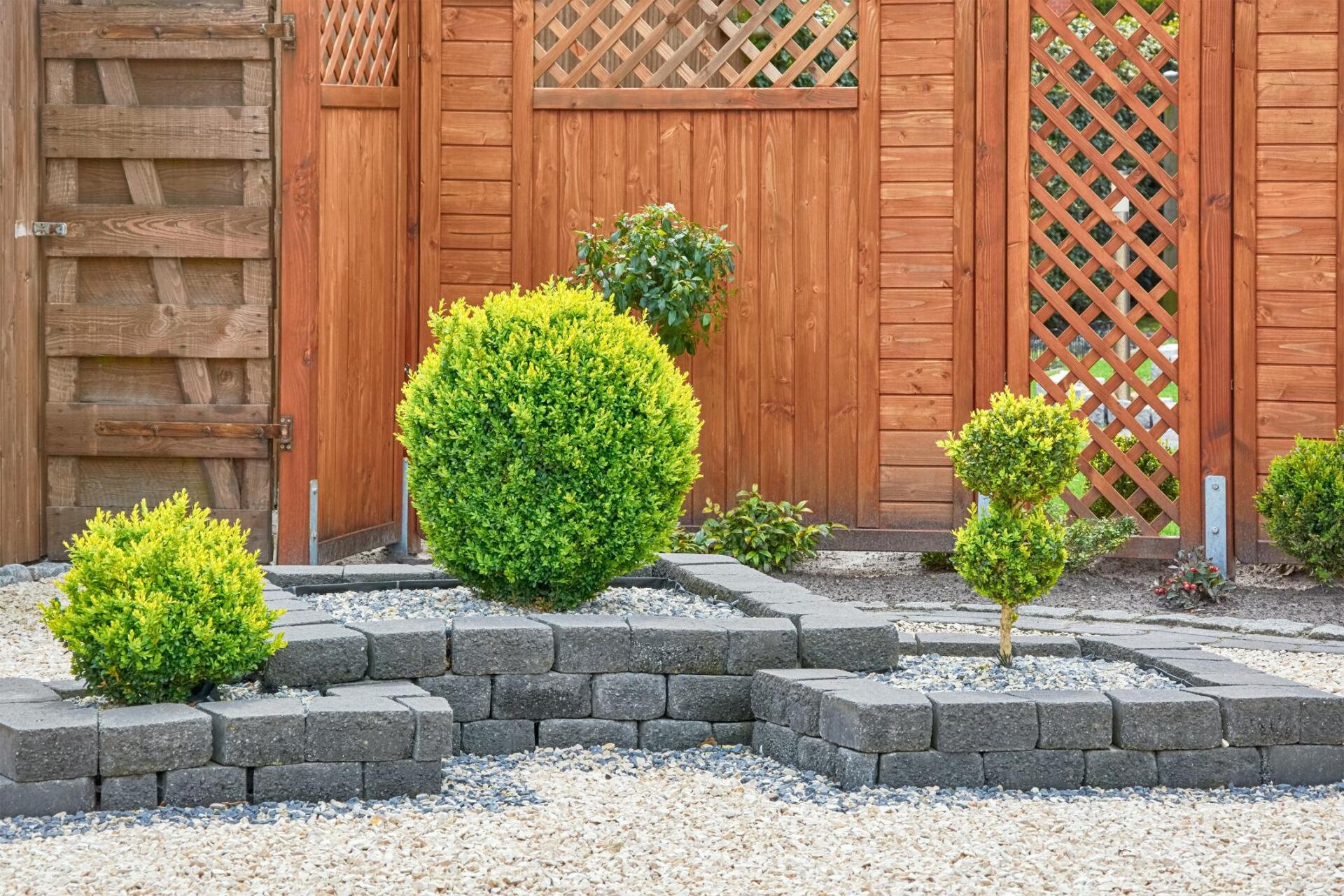 Landscape Design in Yorba Linda. Newly constructed landscape design with a gate, wooden fencing, landscape rock, three trees and some paving work