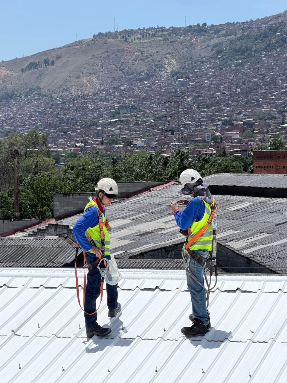 Bajantes de metal galvanizado y sifón en forma de U montados en una pared de edificio de color beige.