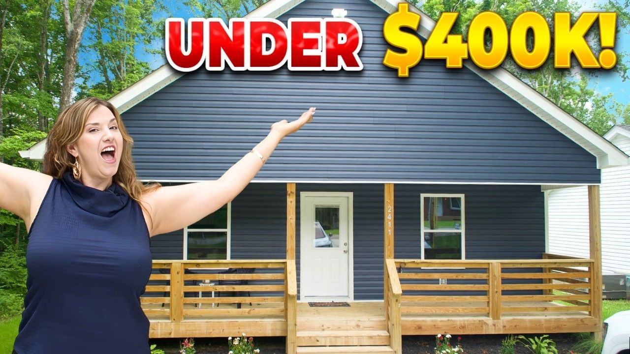 Woman standing by a small blue house with a porch and “UNDER $400K!” text above it