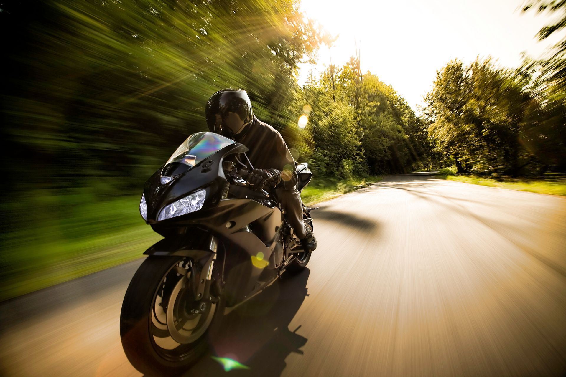 A man is riding a motorcycle down a road.