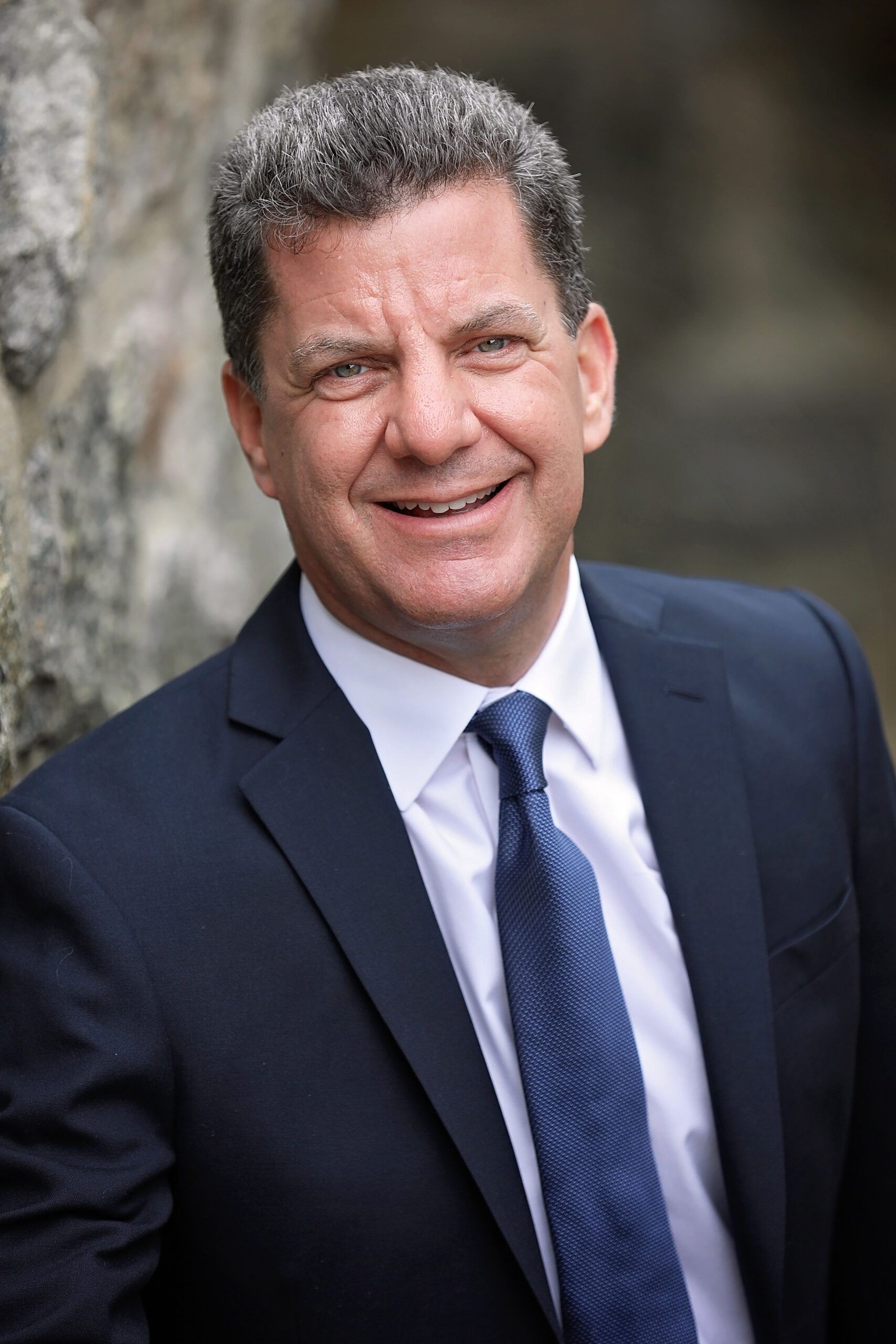 A man in a suit and tie is smiling for the camera.