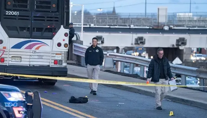 A bus is parked on the side of the road next to a police tape.