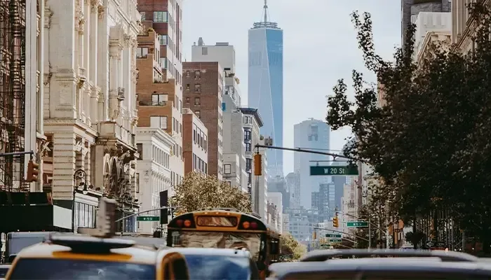 A yellow school bus is driving down a busy city street.