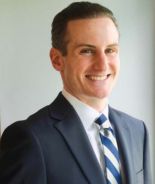 A man in a suit and tie is smiling for the camera.