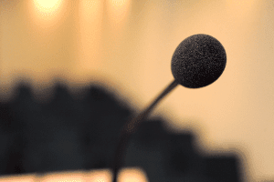 A close up of a microphone on a stand in front of a podium.