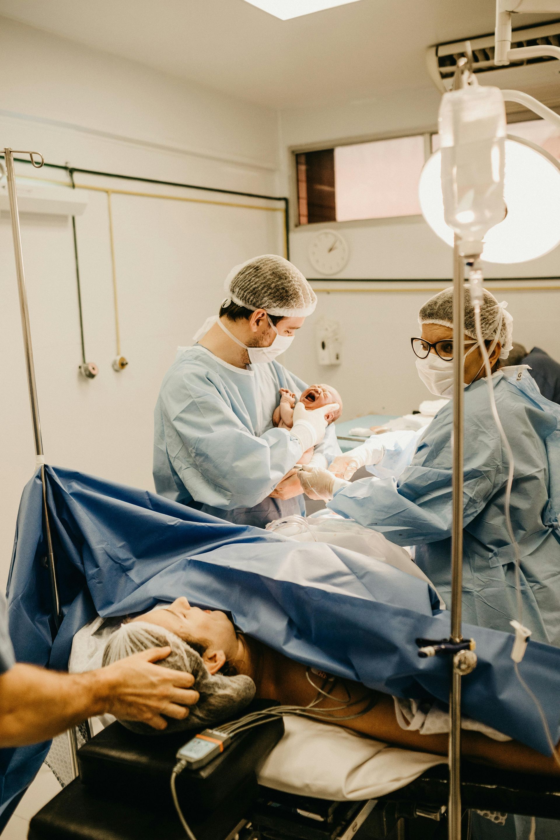 A group of surgeons are operating on a patient in an operating room.