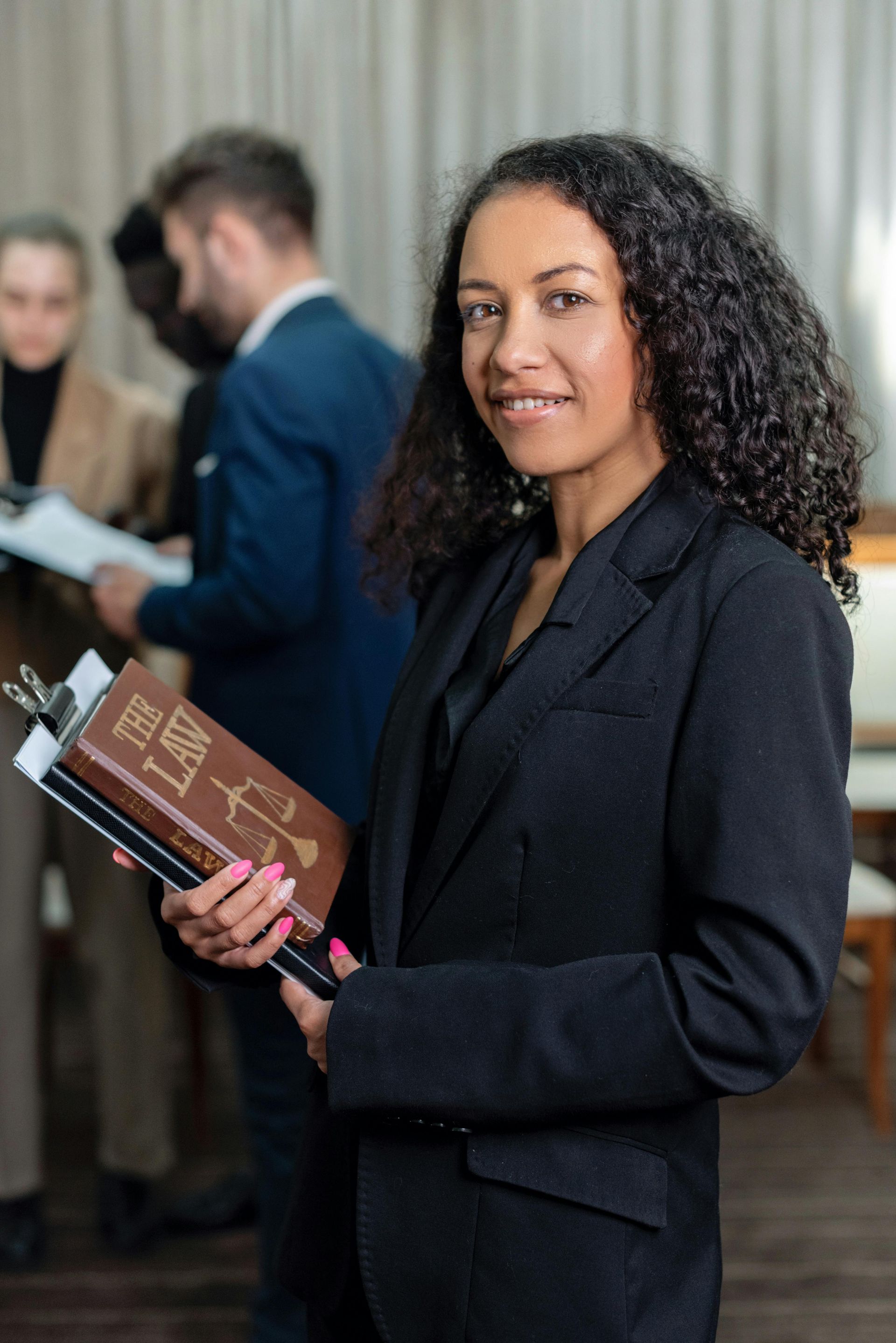 A woman in a suit is holding a sign in her hands.