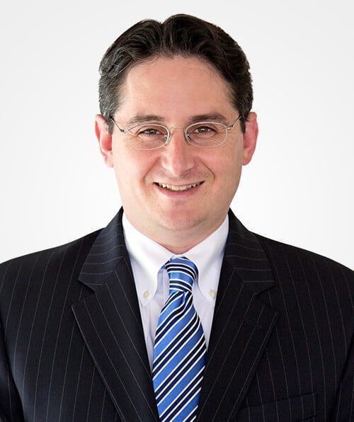 A man in a suit and tie is smiling for the camera.