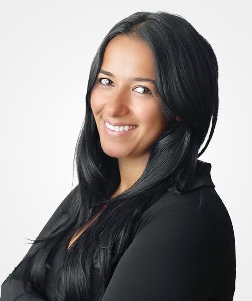 A Woman in a black shirt with long black hair smiling for the camera.