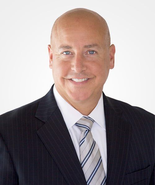 A man in a suit and tie is smiling for the camera.