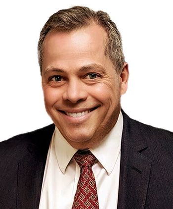 A man in a suit and tie is smiling for the camera.