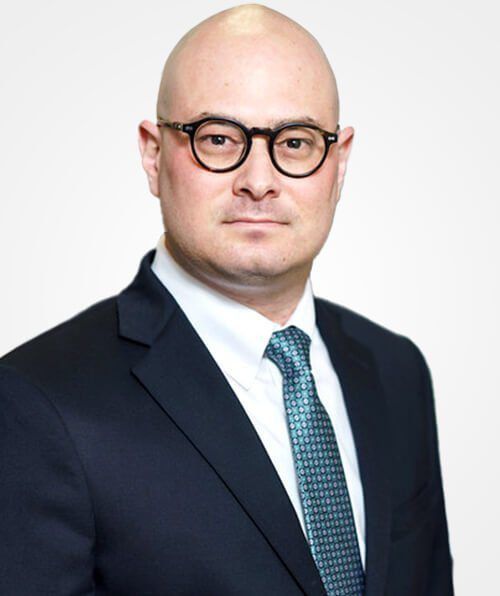 A bald man wearing glasses and a suit and tie