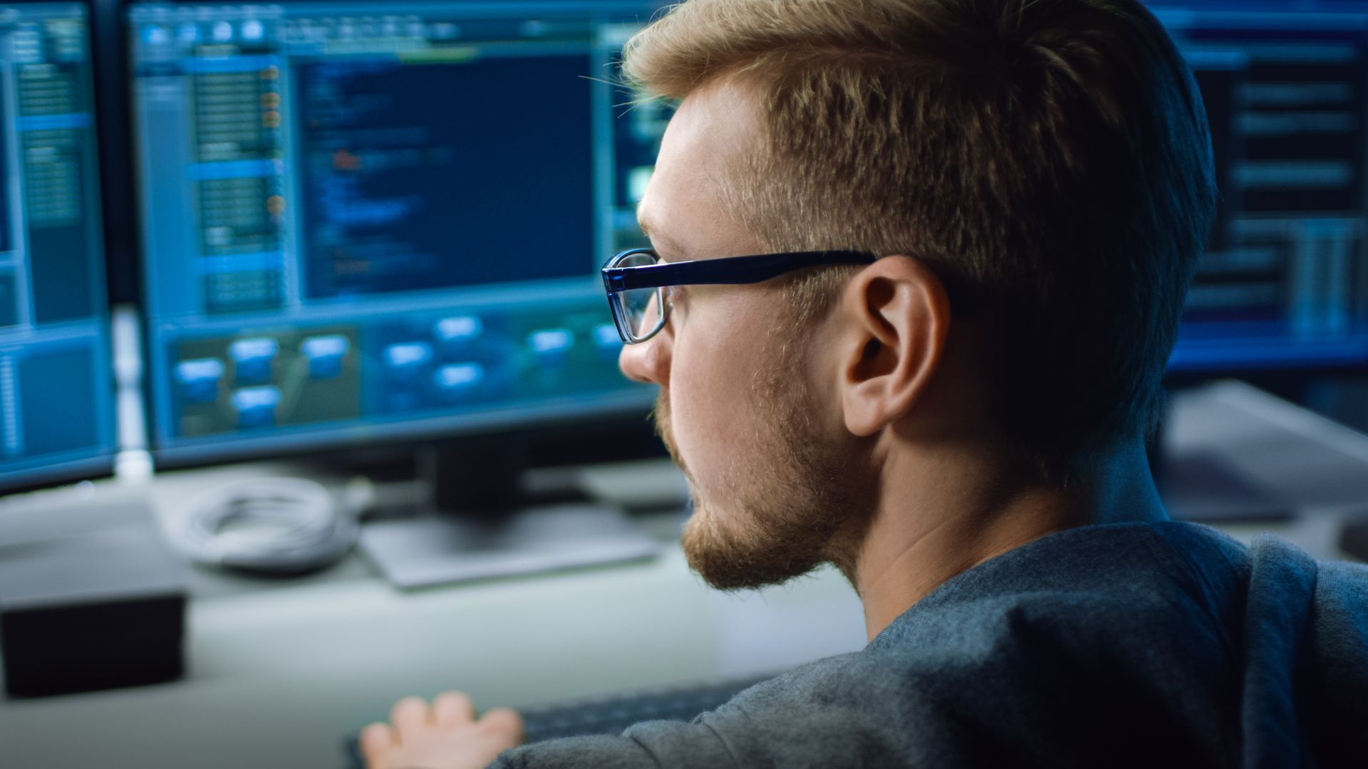 IT specialist working on computer with coding software interface. IT specialist working on computer with coding software interface.
