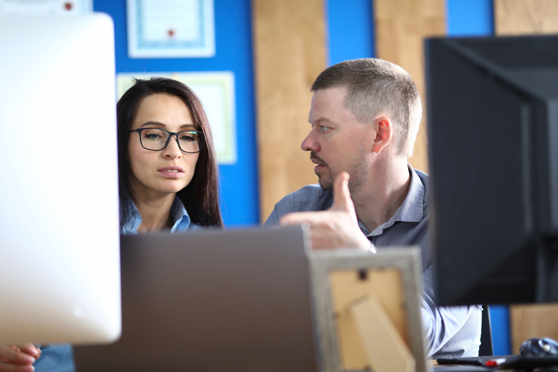 IT consultant reviewing computer setup with a business worker.