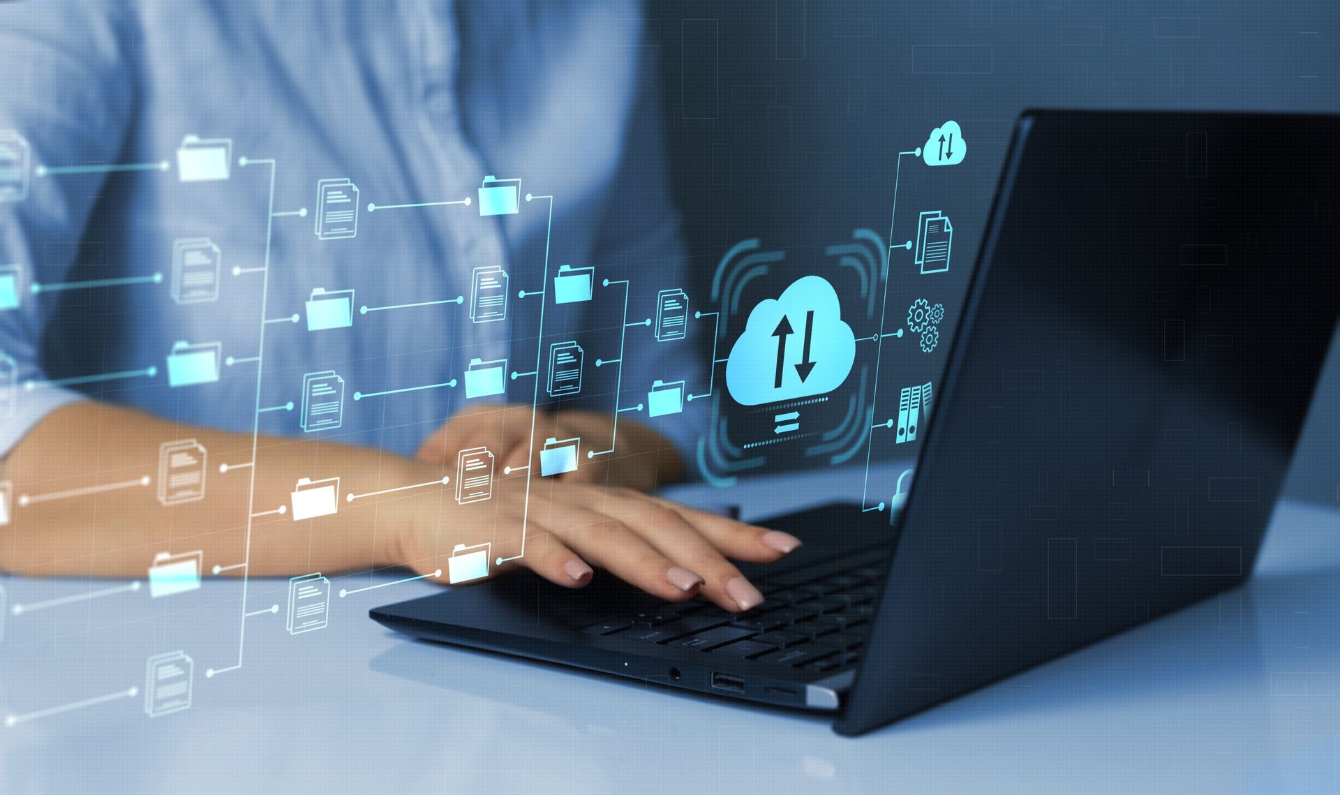 Person using laptop with digital cloud storage and file transfer icons.