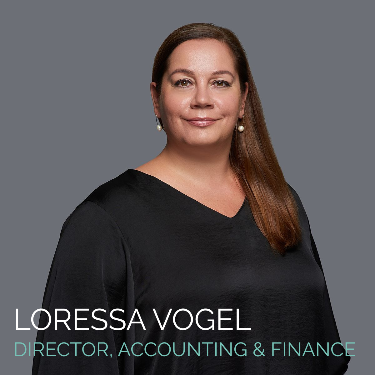 Loressa Vogel, Director of Accounting & Finance, in black top, smiling, against a gray backdrop.