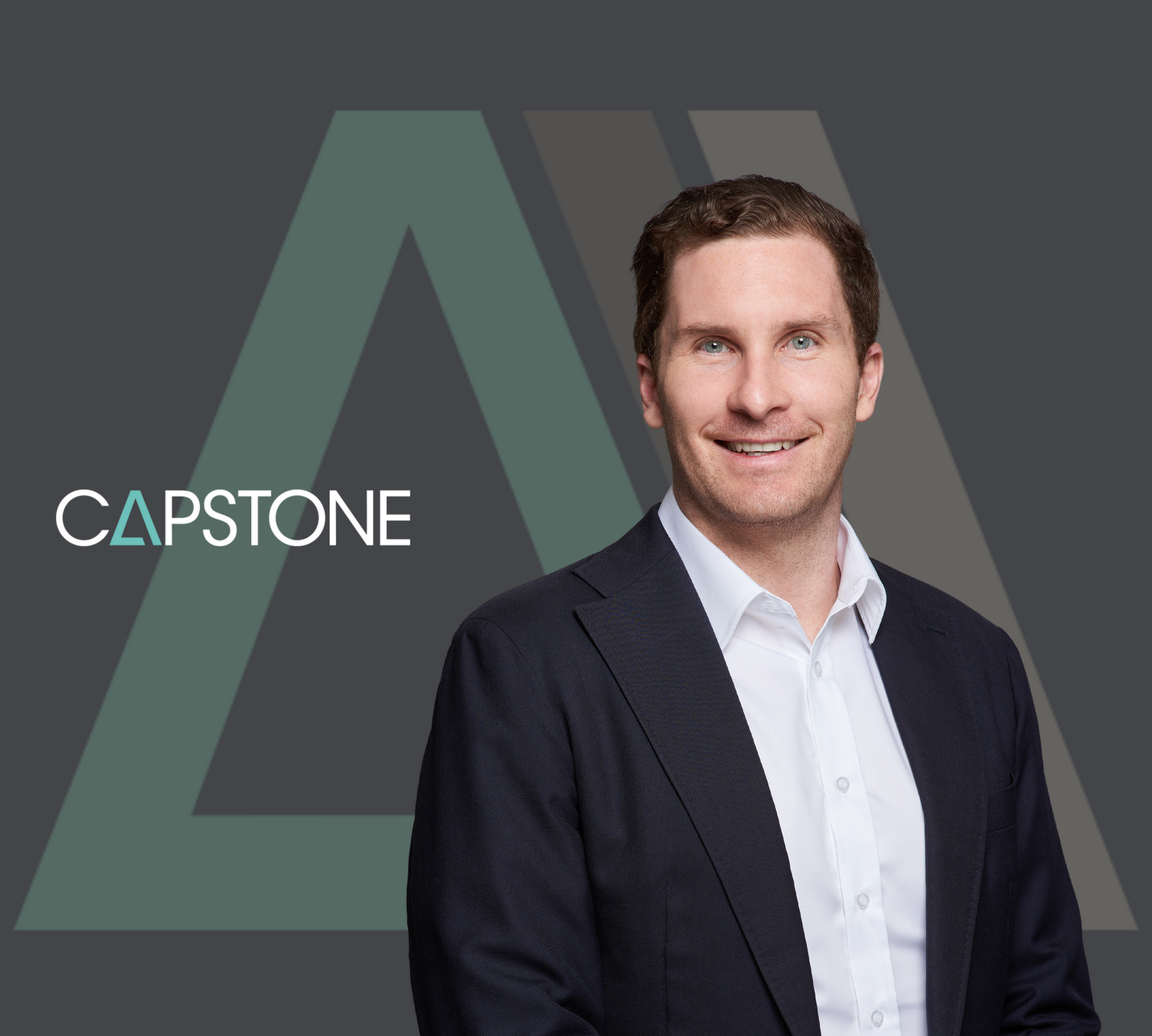 Man in suit smiling, with Capstone logo and abstract shape in background.