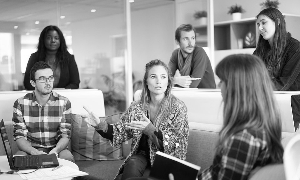 A group of people are sitting around a table having a meeting.