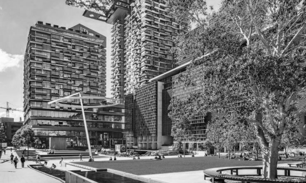 A black and white photo of a city with tall buildings and trees.