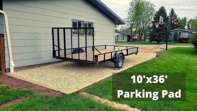 A utility trailer parked on a rectangular gravel pad measuring 10 by 36 feet next to a house exterior.