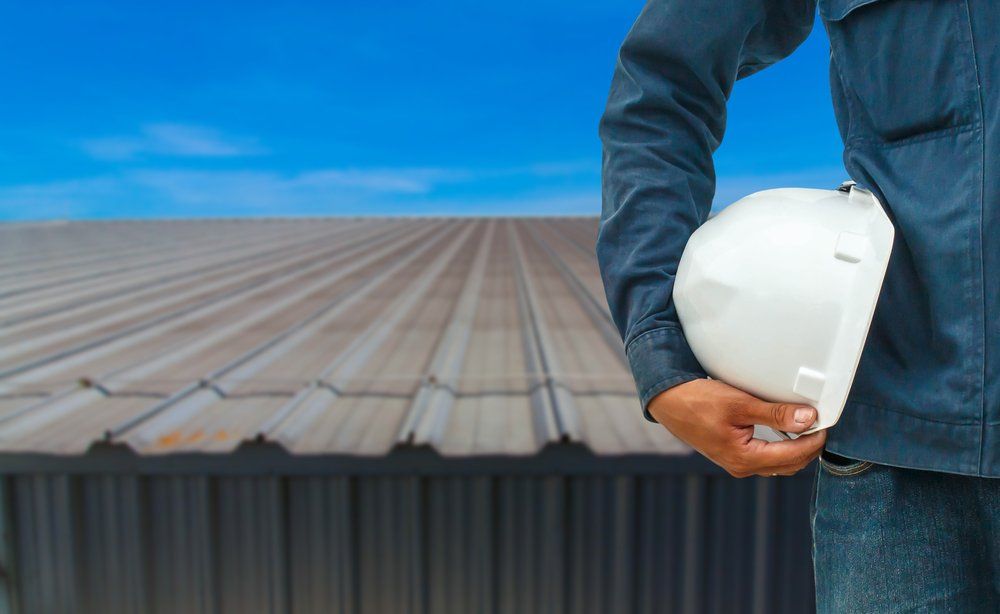 Roof Worker Holding a Hard Helmet — Roofing in Goulburn, NSW